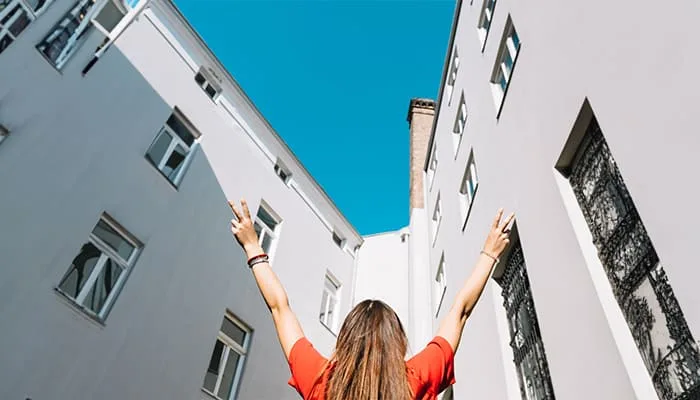 mujer-haciendo-gesto-paz-cerca-edificio-residencial-en-granada-coliving (1)
